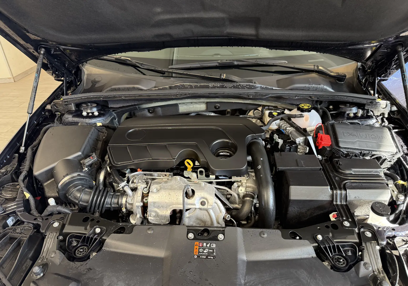 Vue rapprochée du moteur diesel de l’Opel Insignia Sports Tourer bleu lune marine métal avec capot ouvert.