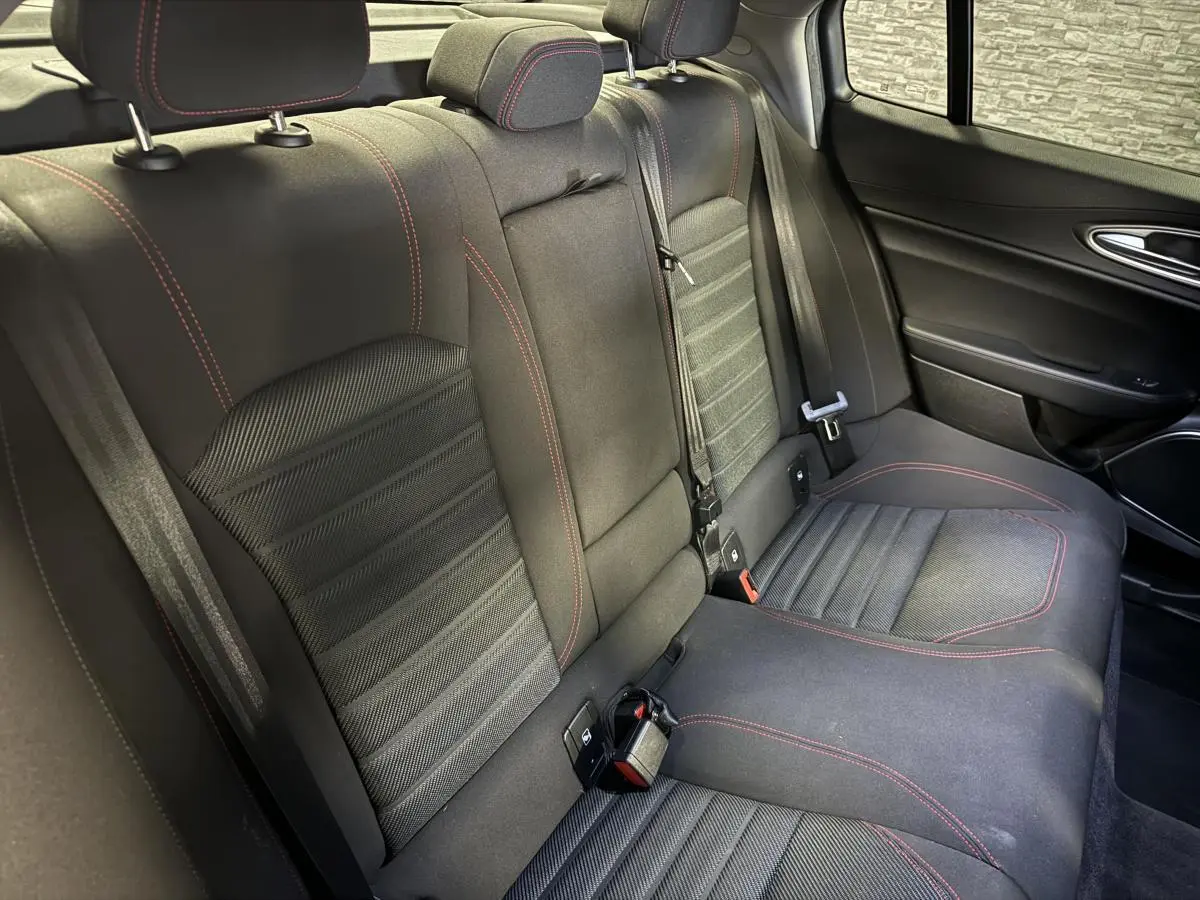Vue intérieure côté droit de la banquette arrière noire avec surpiqûres rouges de l'Alfa Romeo Giulia 2.2 D 2021.