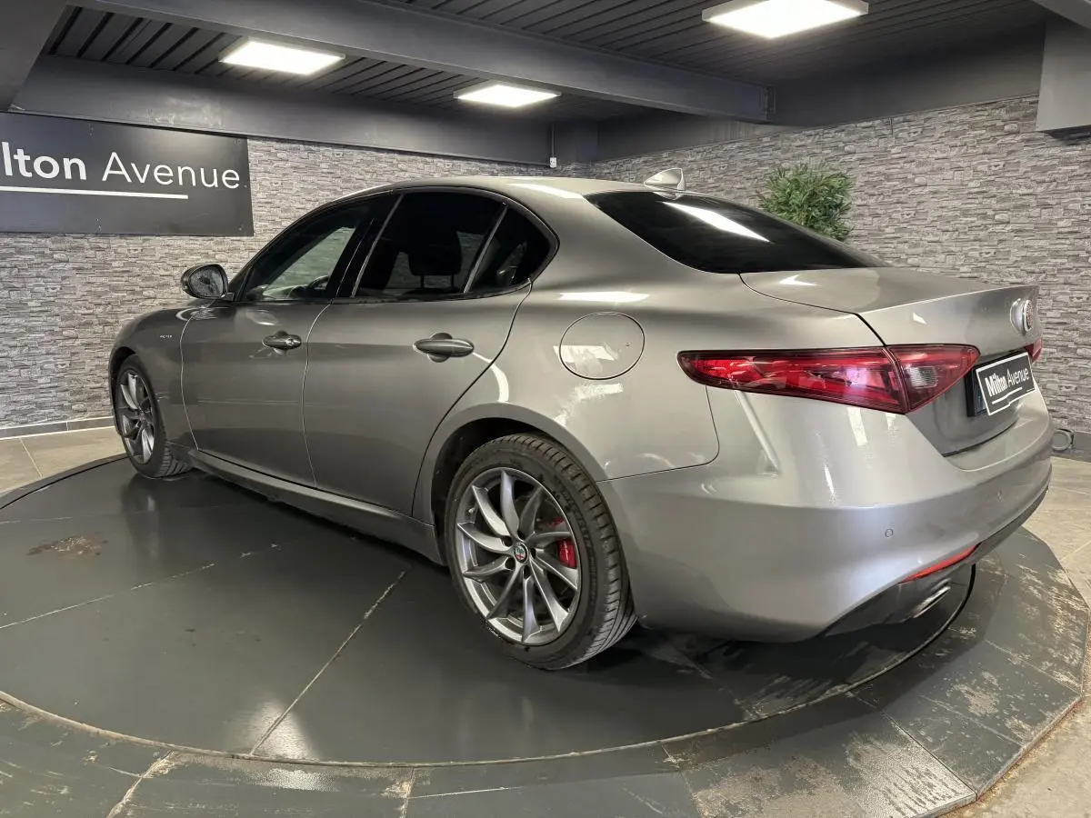 Vue 3/4 arrière droite de l'Alfa Romeo Giulia gris métallisé avec jantes alliage 18 pouces Aero Scuro et vitres surteintées.