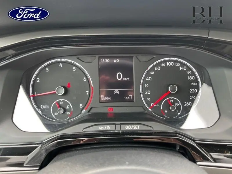 Vue rapprochée du tableau de bord digital d'une Volkswagen Polo blanche, affichant la vitesse à 0 km/h.