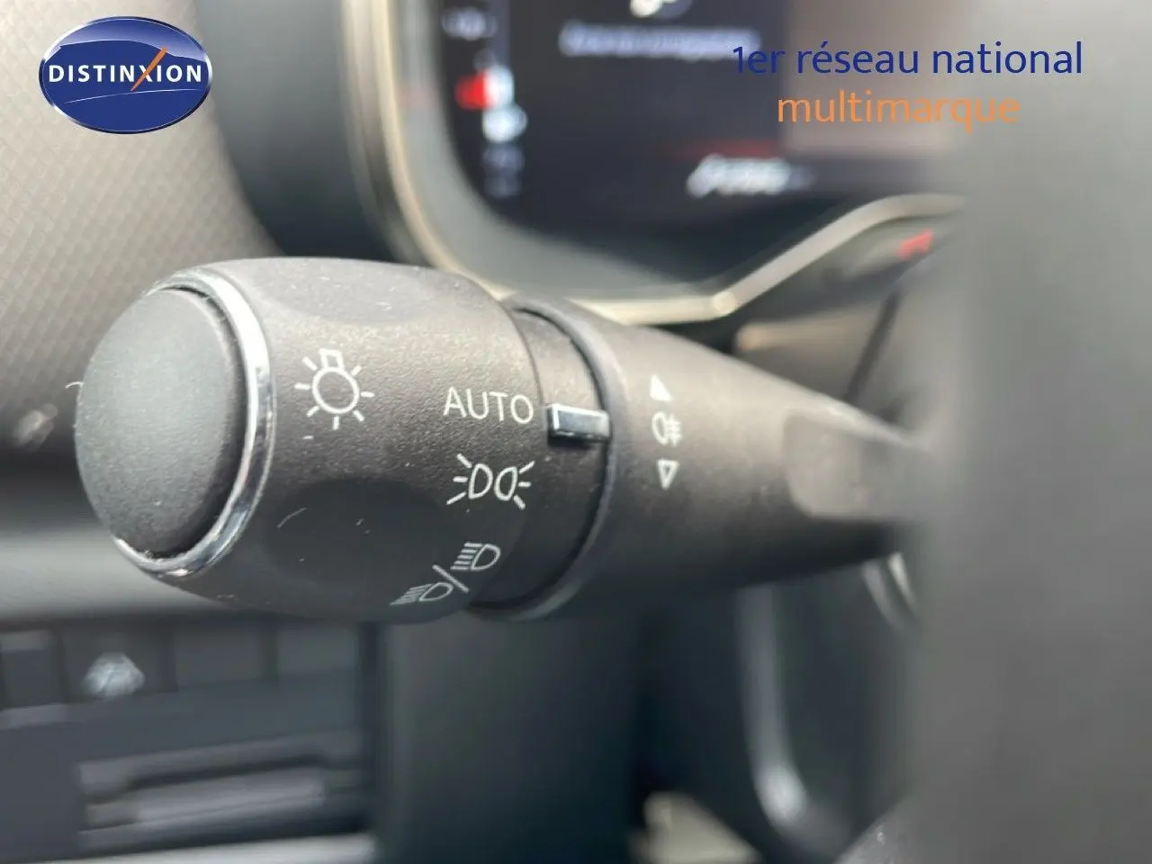 Gros plan sur la commande des phares à gauche du volant dans l'habitacle du Citroën C5 Aircross bleu Eclipse Metal.