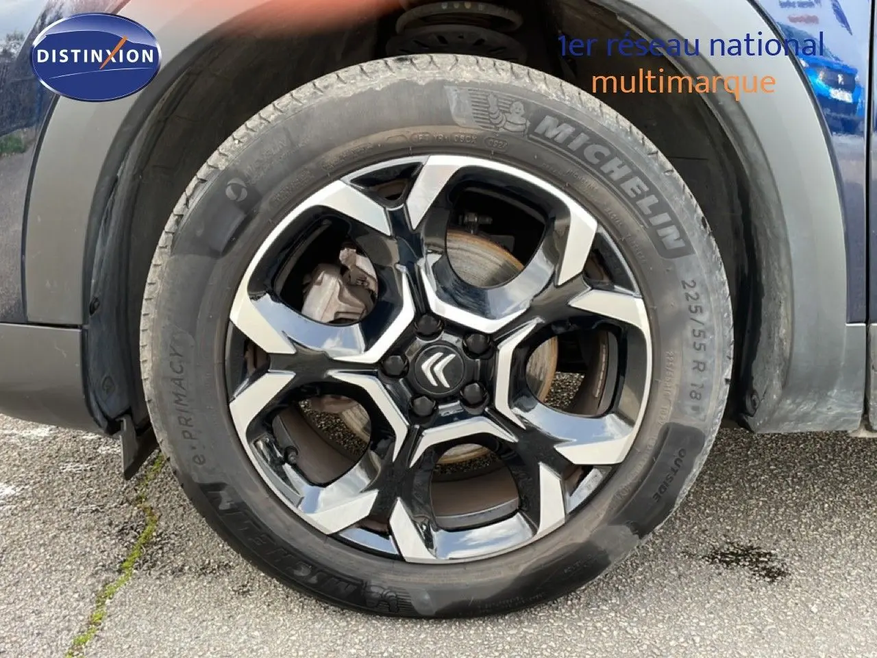 Gros plan sur la roue avant droite avec jante noire et argentée du Citroën C5 Aircross bleu Eclipse Metal 2024.