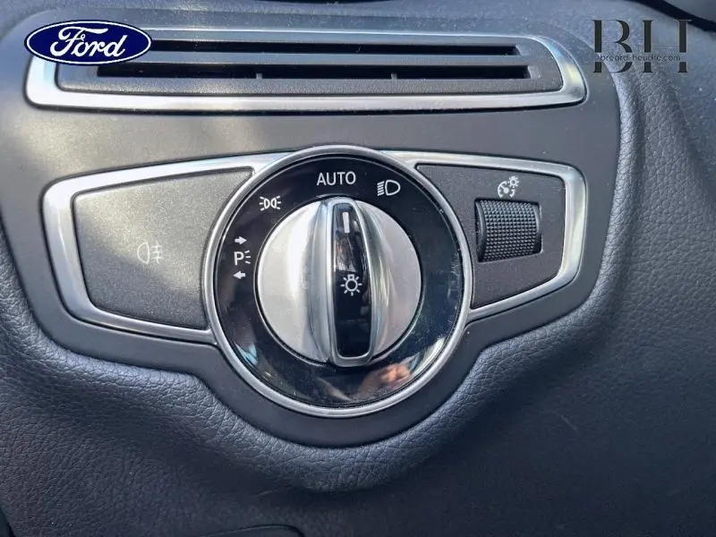 Commande des phares en gros plan sur tableau de bord noir d'une Mercedes Classe C 200 d Business argent iridium.