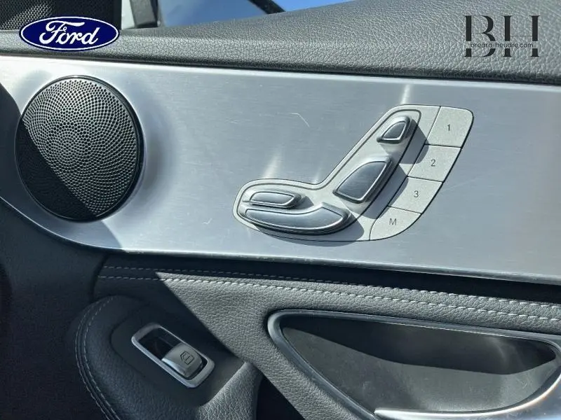 Détail des commandes de réglage de siège sur la porte côté gauche d'une Mercedes Classe C 200 d Business argent iridium.