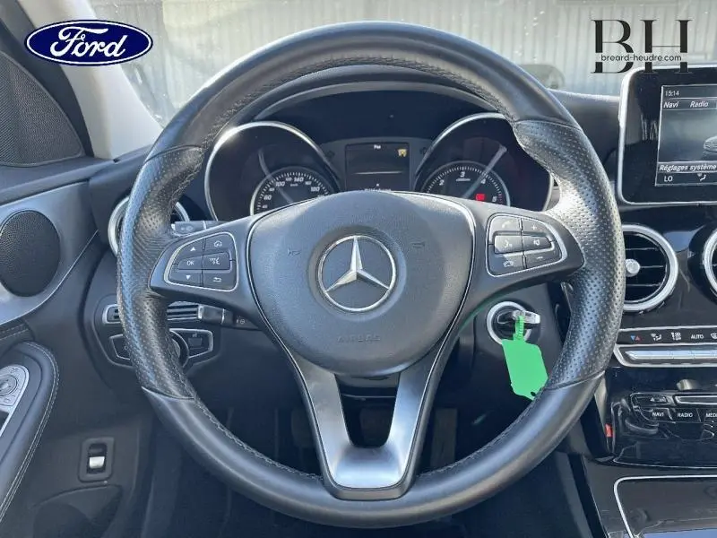 Vue intérieure centrée sur le volant cuir noir avec logo Mercedes d'une Classe C 200 d Business argent iridium.