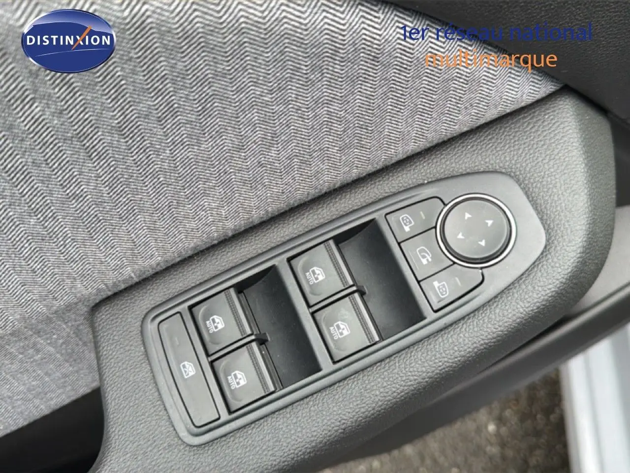 Commande des vitres électriques et réglage des rétroviseurs sur la portière côté conducteur d'une Renault Clio gris Rafale.