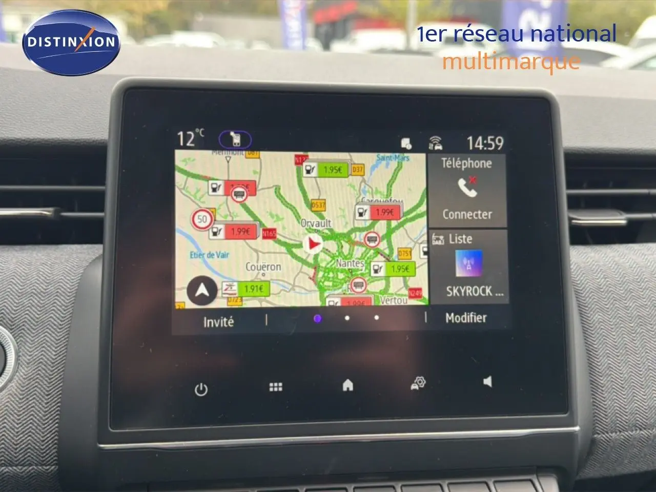 Vue rapprochée de l’écran tactile du tableau de bord de la Renault Clio gris Rafale, affichant la navigation et les options multimédia.