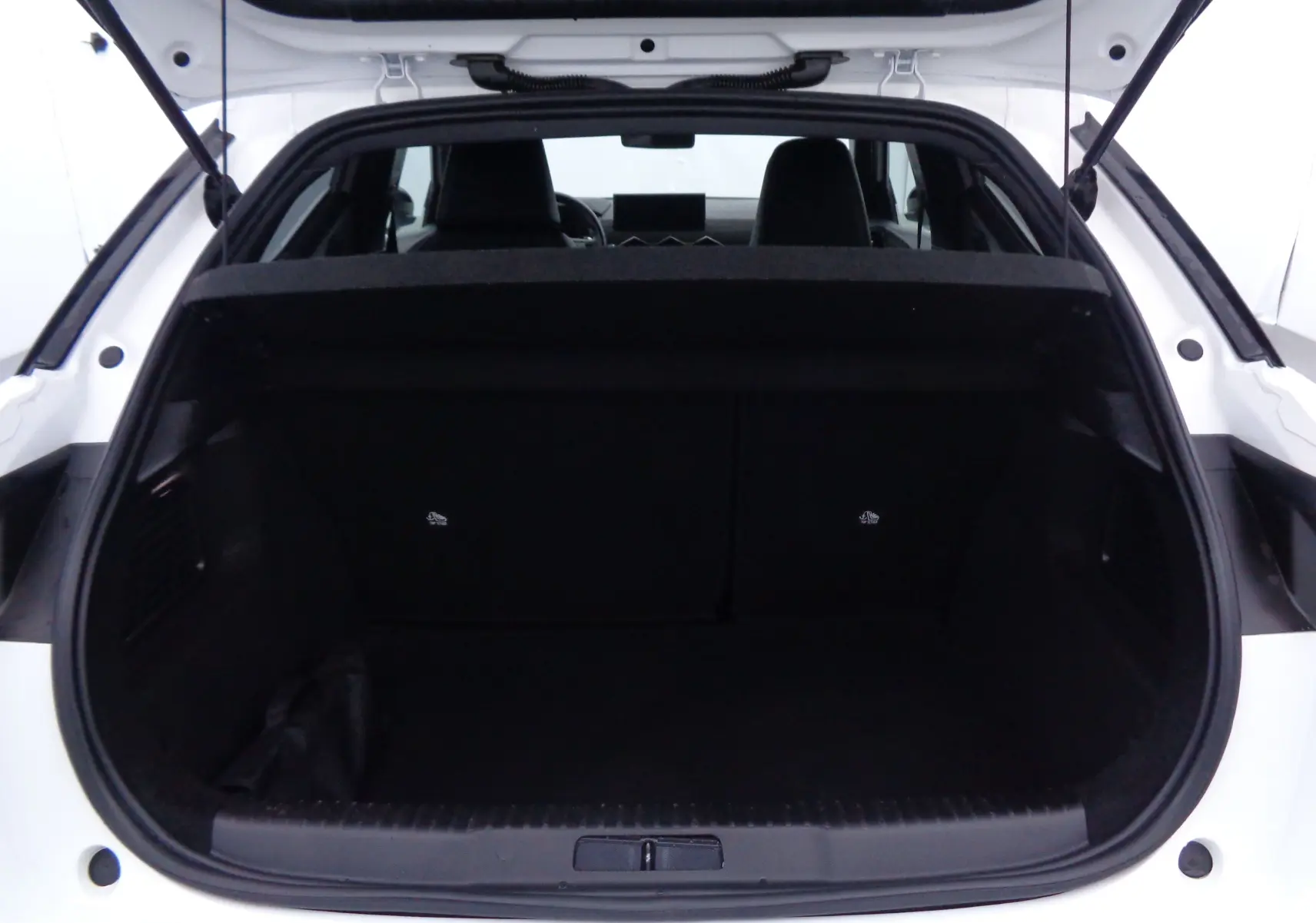 Coffre ouvert vu de l'arrière d'un DS3 Crossback blanc banquise, intérieur noir et banquette arrière visible.