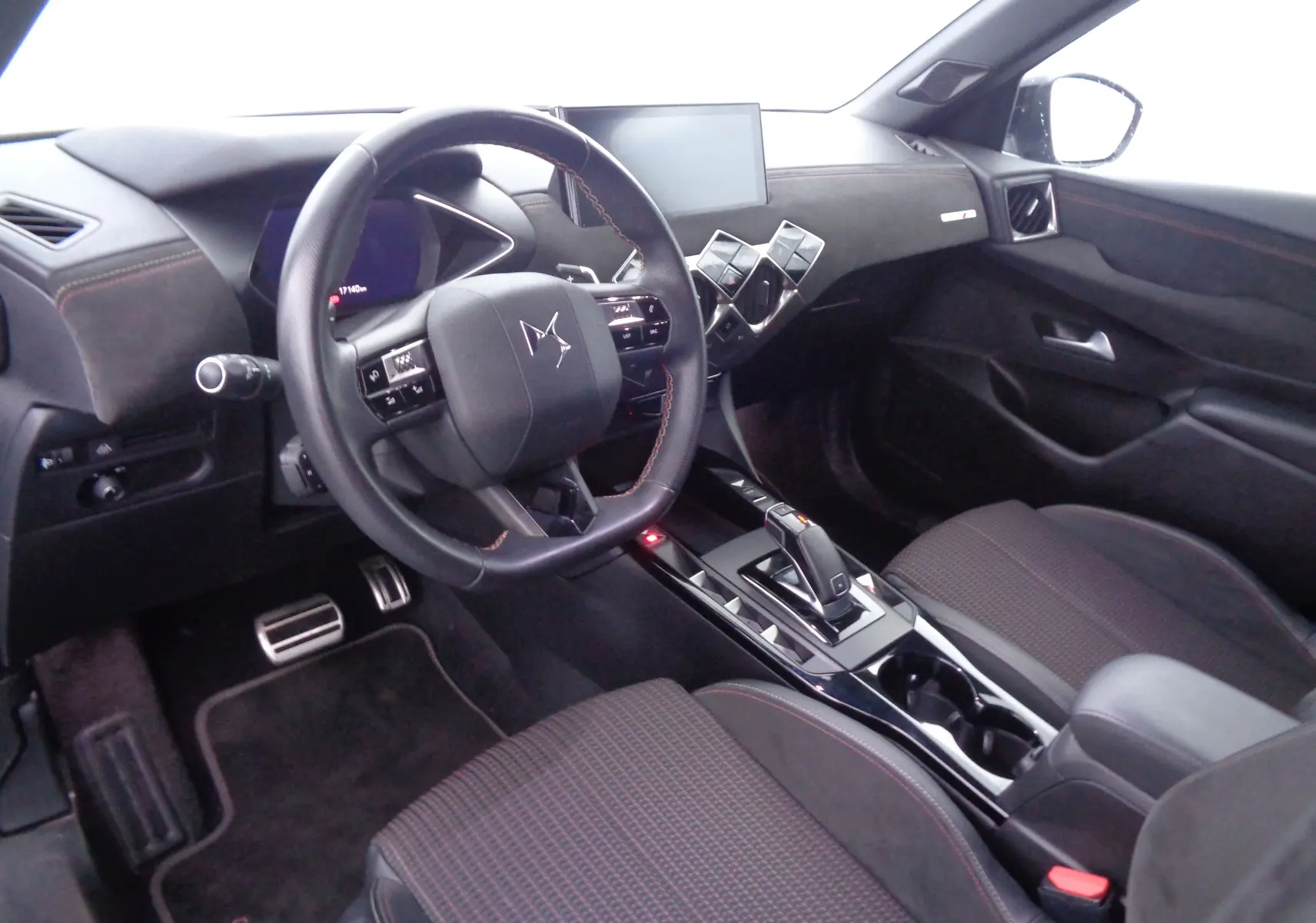 Intérieur du DS3 Crossback 2021 vu côté conducteur, tableau de bord noir avec volant multifonction et console centrale moderne.