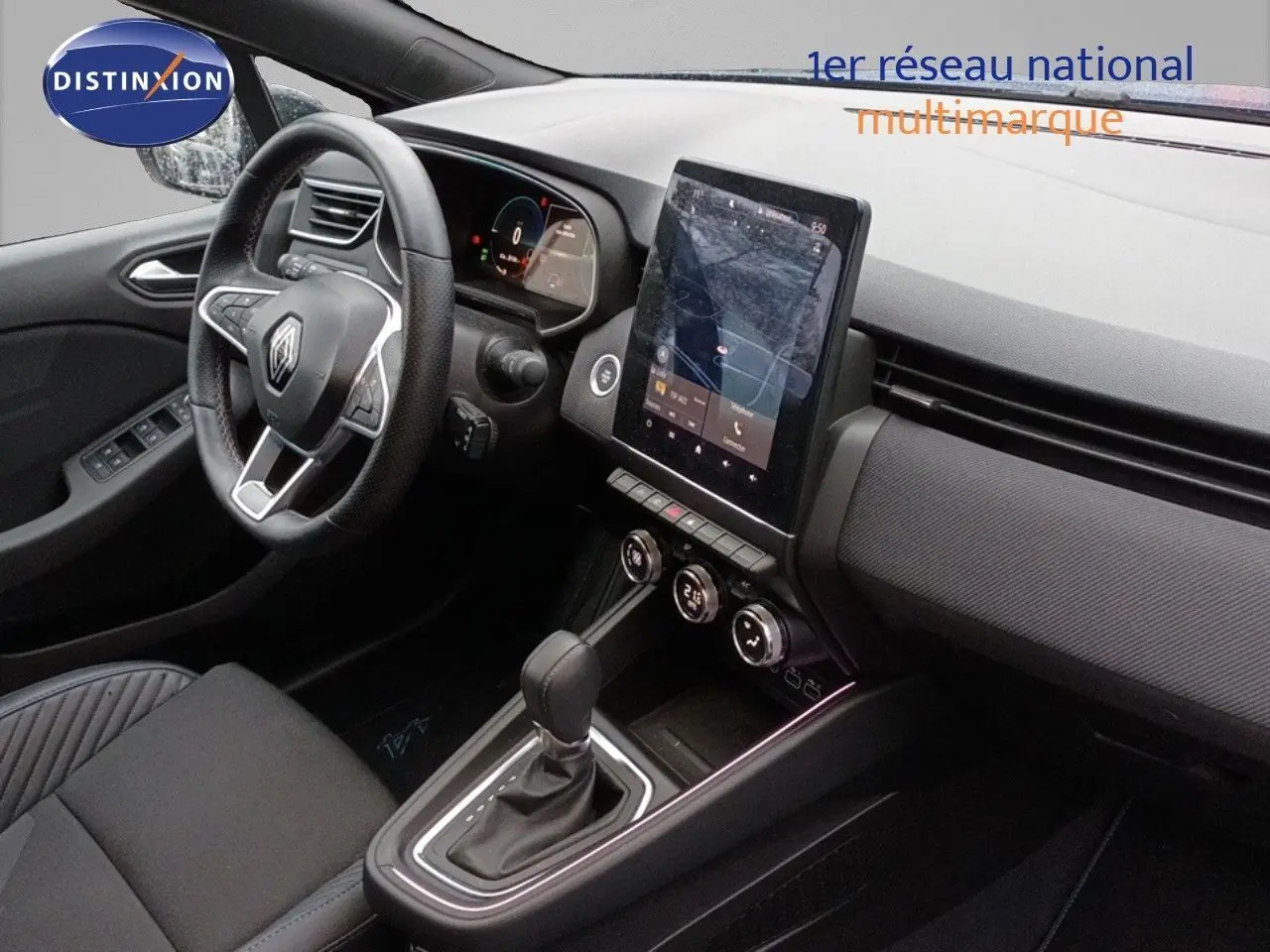 Intérieur de Renault Clio 2024, vue côté conducteur, tableau de bord avec écran tactile vertical et levier de boîte auto.