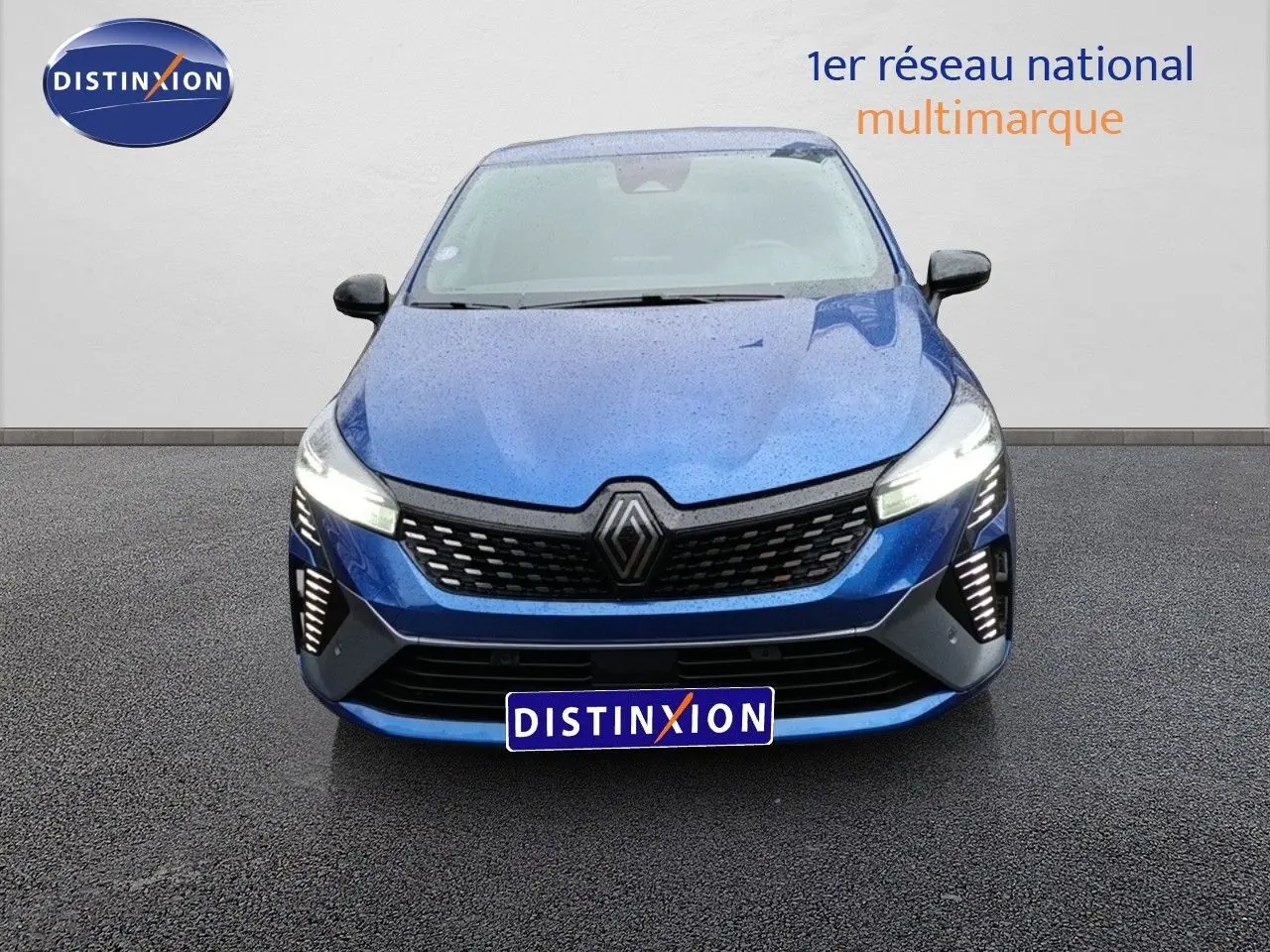 Vue frontale d'une Renault Clio 1.6 E-TECH 145ch Full Hybrid Esprit Alpine en bleu Iron Metal avec feux allumés.