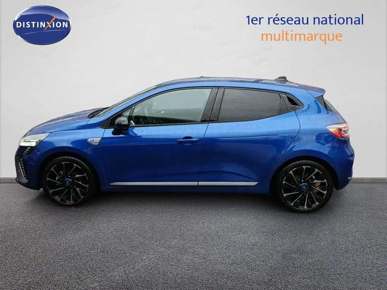 Profil droit d'une Renault Clio 1.6 E-TECH 145ch hybride en bleu Iron Metal avec jantes noires stylées.