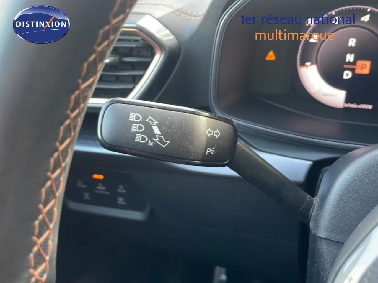 Gros plan sur la manette de clignotant à gauche du volant dans l’habitacle noir du CUPRA Formentor blanc neige 2025.