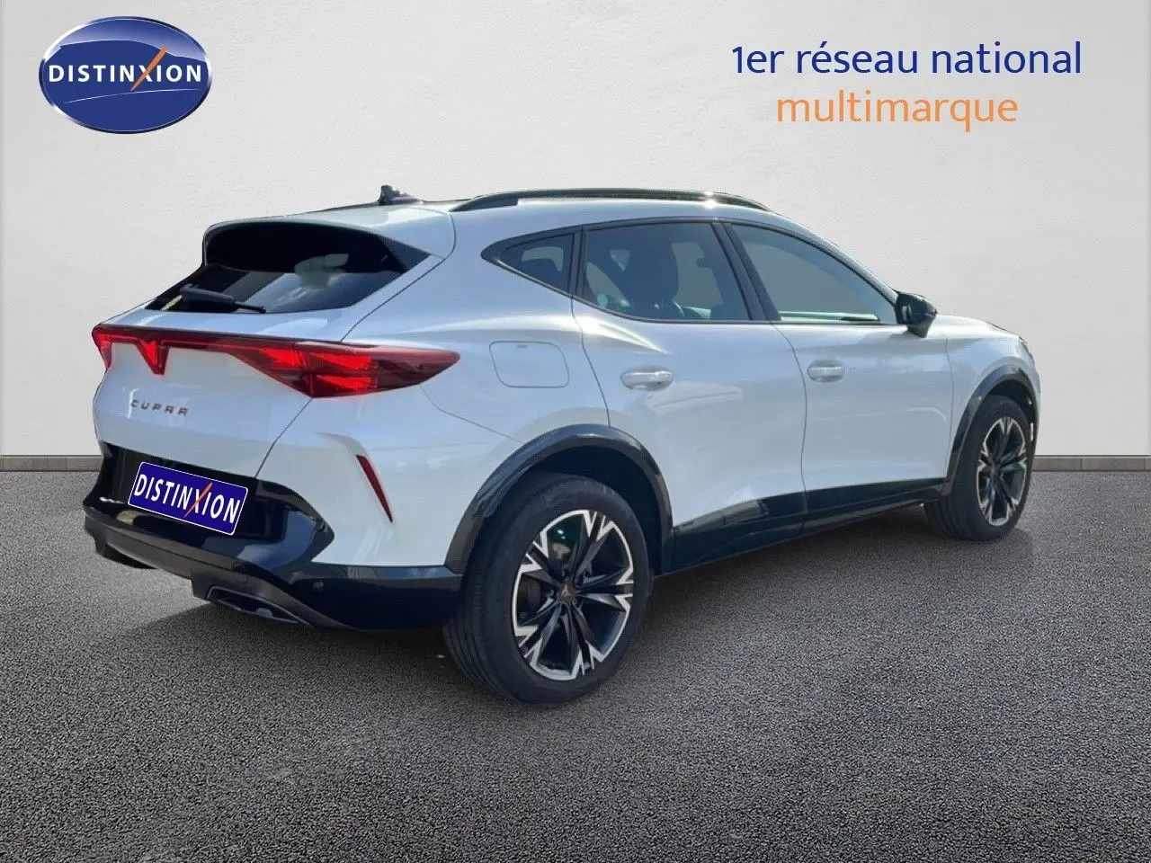 Vue 3/4 arrière droite du CUPRA Formentor blanc neige métal avec jantes noires et feux arrière LED distinctifs.