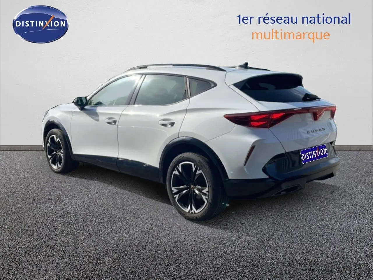 Vue 3/4 arrière droite d'un CUPRA Formentor blanc neige métal avec jantes noires et toit panoramique.