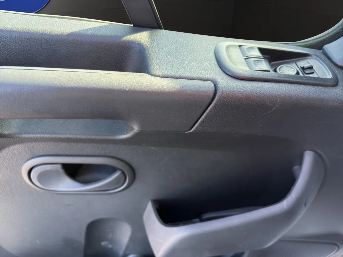 Détail de la porte intérieure côté conducteur du Nissan Interstar 2024, avec commandes électriques et poignée noire.