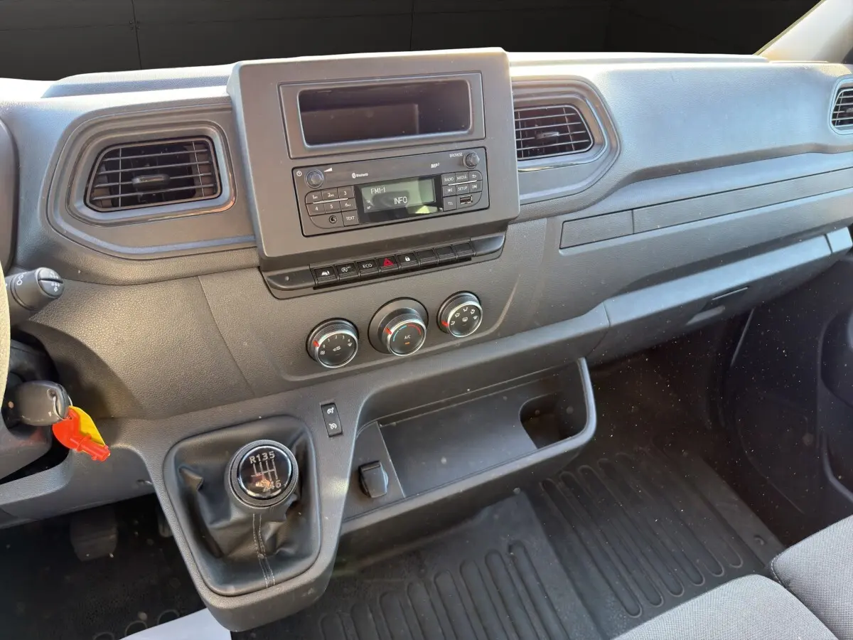 Vue intérieure du tableau de bord du Nissan Interstar 2024 avec boîte manuelle et commandes centrales noires.