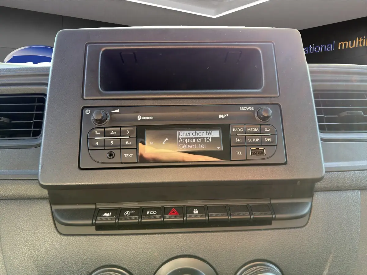 Vue rapprochée du tableau de bord noir du Nissan Interstar 2024, avec système audio et commandes visibles.