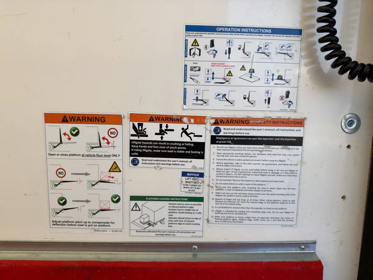Détail des consignes de sécurité sur la porte arrière blanche du Nissan Interstar 2024, vue rapprochée.