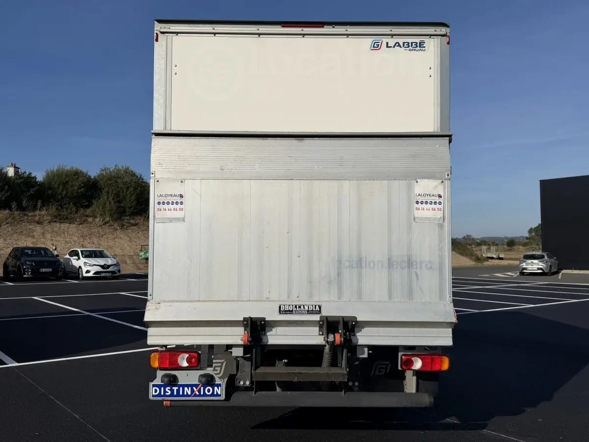 Vue arrière d’un utilitaire blanc Nissan Interstar avec hayon élévateur et marquages LABBE sur caisse.