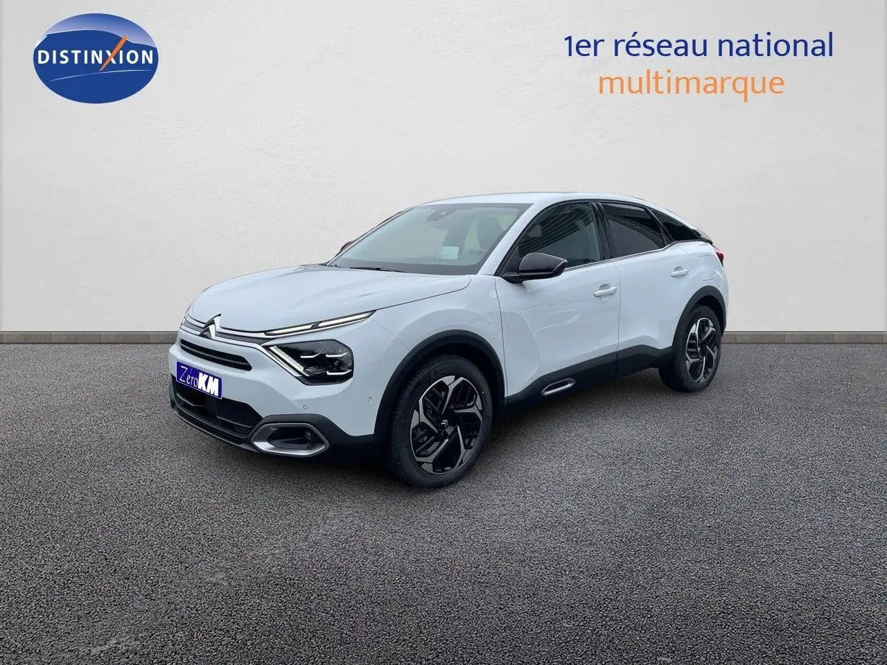 Citroën C4 blanc métal vue 3/4 avant droit avec jantes noires et toit noir contrasté sur sol gris.