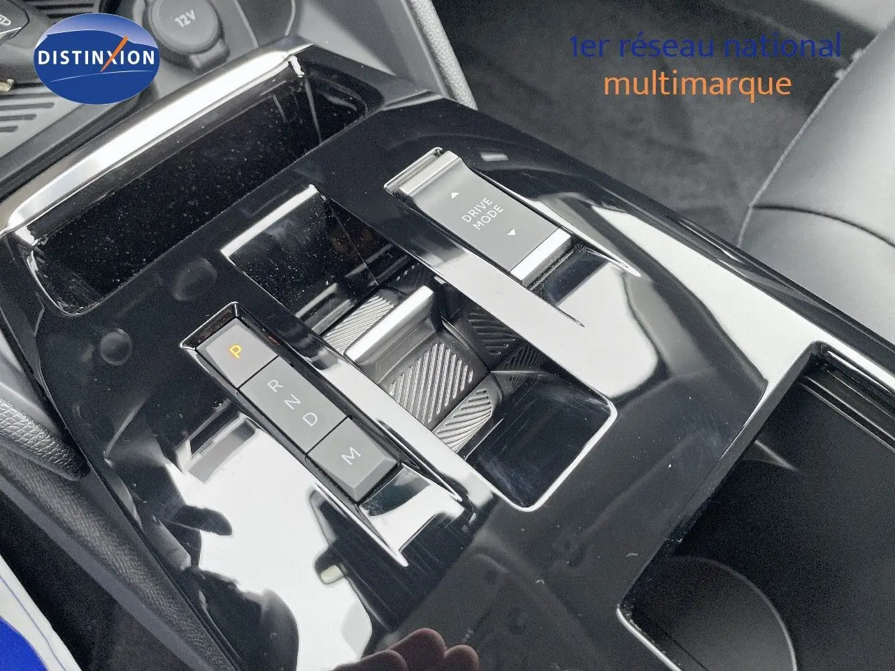 Gros plan sur la console centrale noire brillante de la Citroën C4 2024, mettant en valeur la commande de boîte automatique et le bouton Drive Mode.