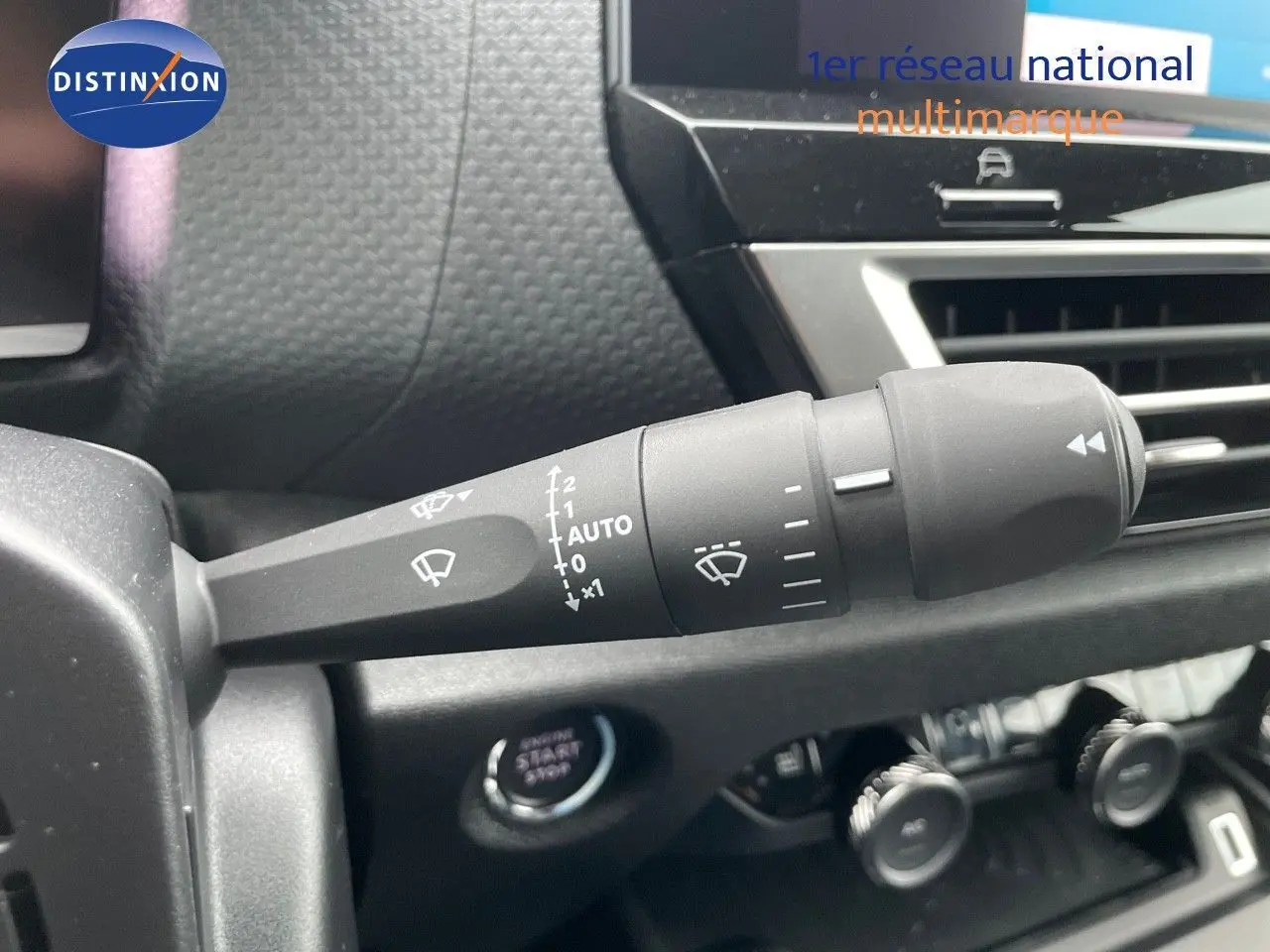 Gros plan sur la commande d'essuie-glace à gauche du tableau de bord d'une Citroën C4 blanche métal 2024.