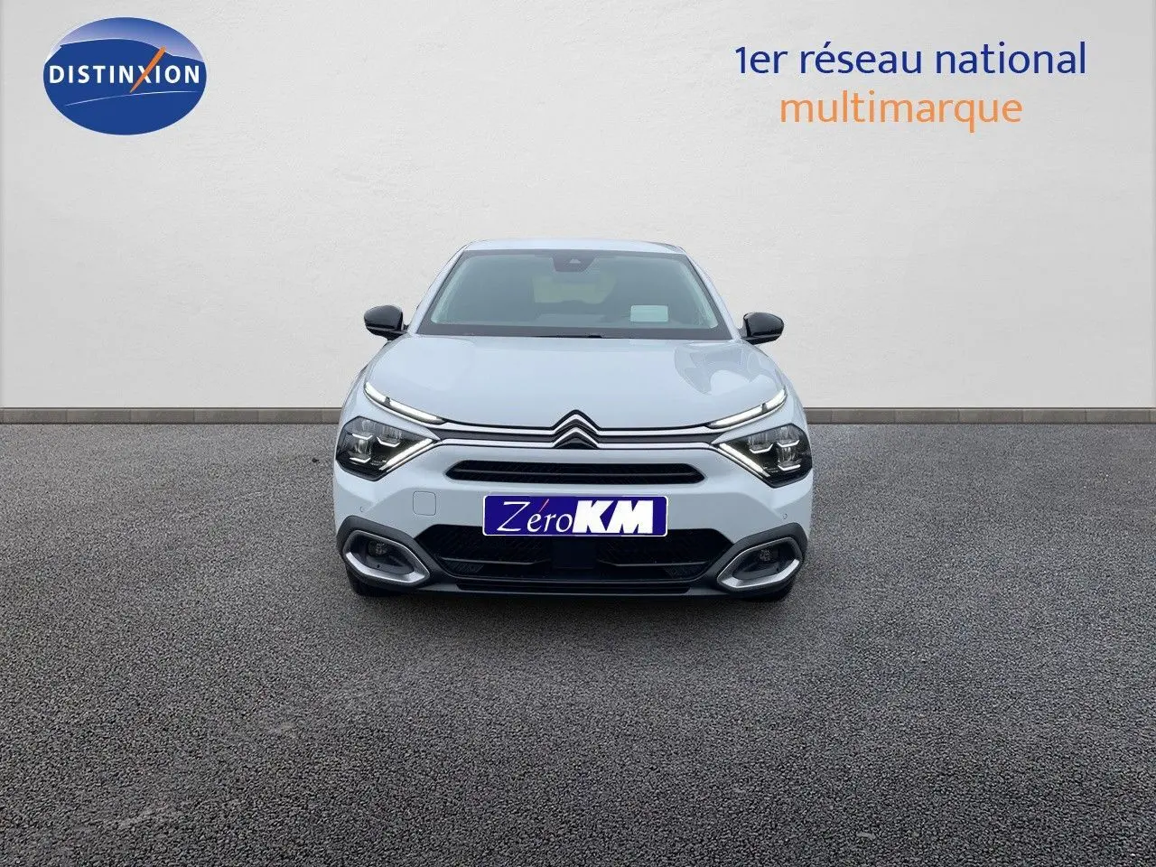 Vue frontale d'une Citroën C4 blanche métal 2024 avec feux LED et calandre distinctive sur fond neutre.