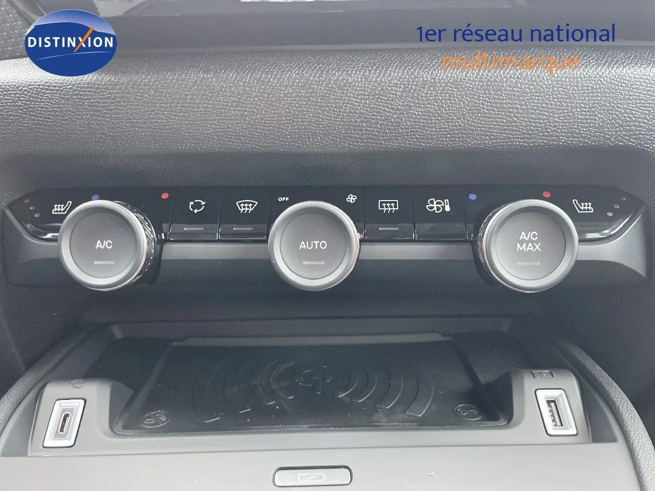 Vue rapprochée de la console centrale de la Citroën C4 blanche, montrant les commandes de climatisation et ports USB.
