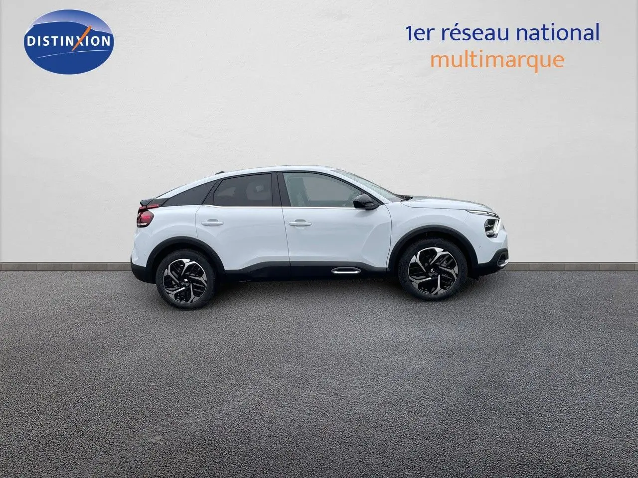 Profil latéral droit d'une Citroën C4 blanche métallisée 2024 avec jantes noires bicolores et toit noir contrasté.