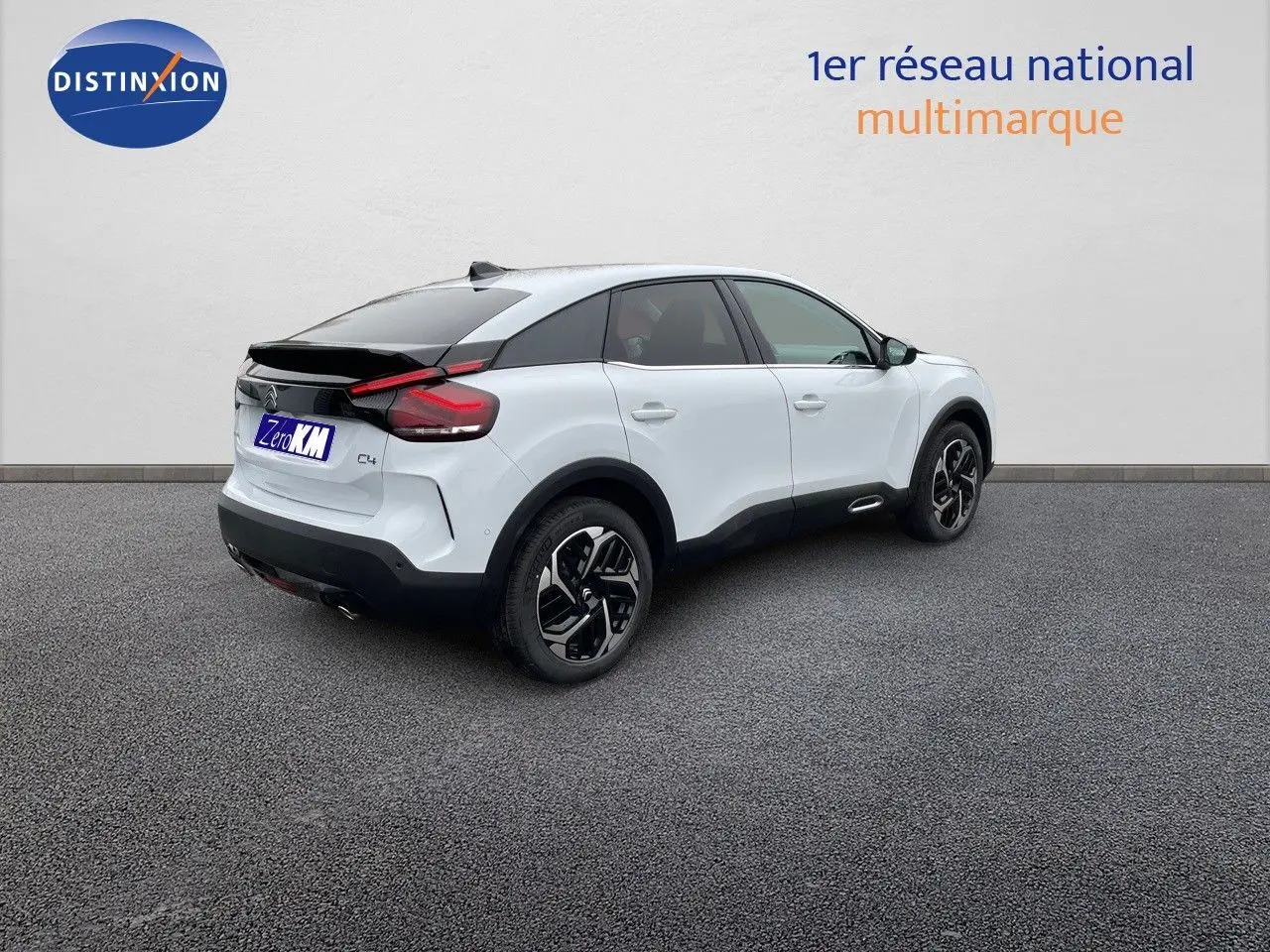 Citroën C4 blanc métal vue 3/4 arrière droit avec toit noir et jantes alliage bicolores.