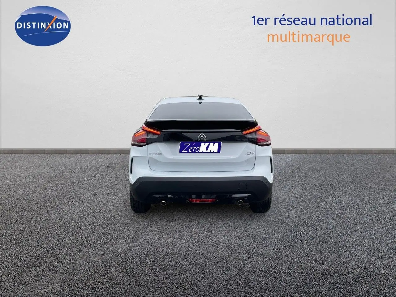 Vue arrière d'une Citroën C4 blanche métal 2024 avec feux LED et double sortie d'échappement visible.