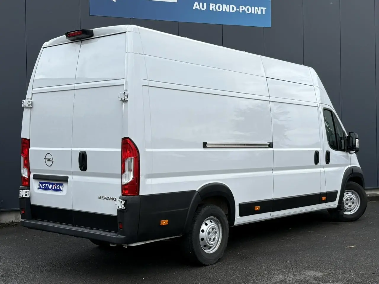 Opel Movano Fourgon blanc vu en 3/4 arrière droit, avec portes arrière battantes et plancher bois visible.