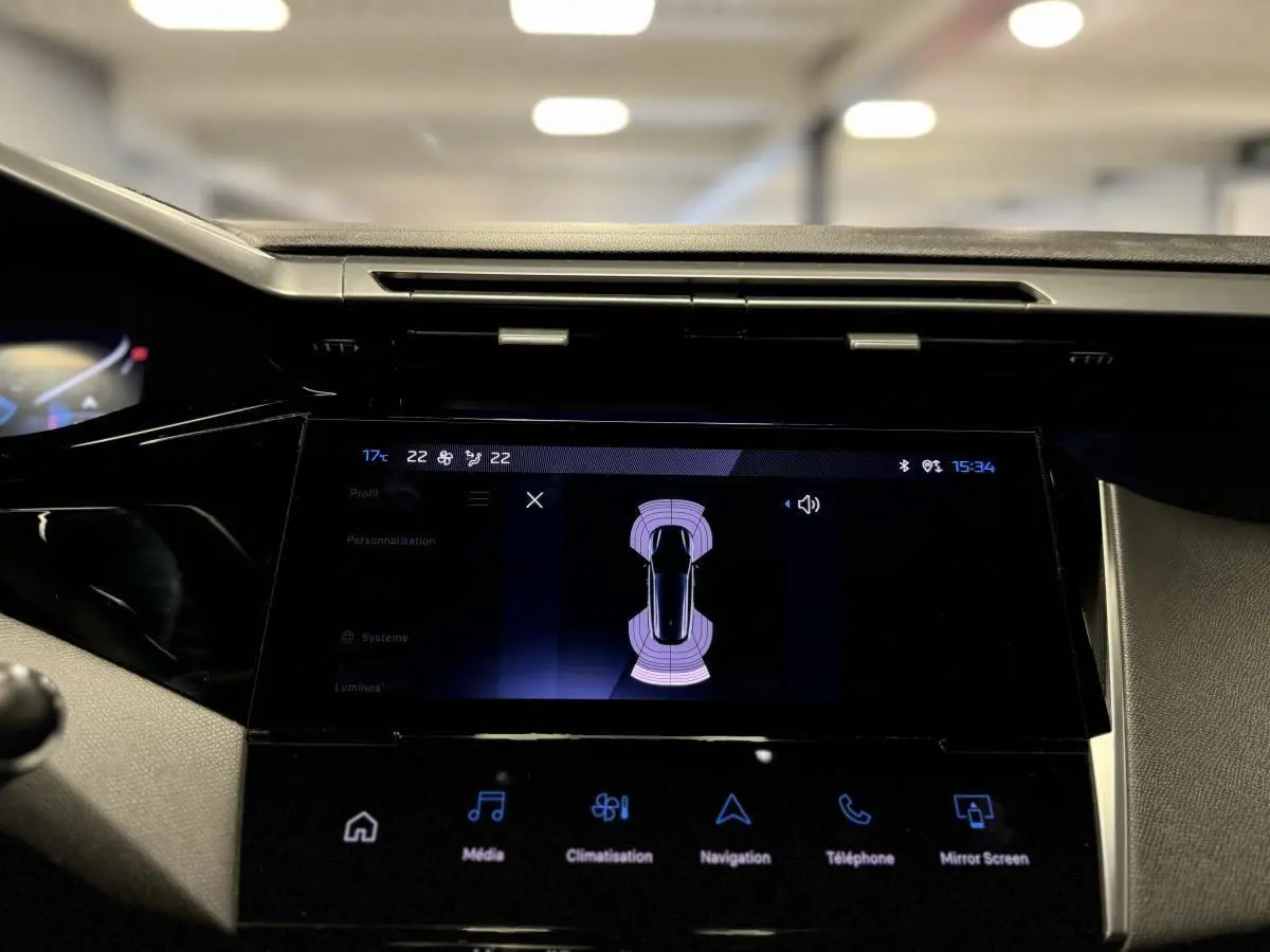 Écran tactile central du tableau de bord de la Peugeot 308 SW gris, affichant l'aide au stationnement active.