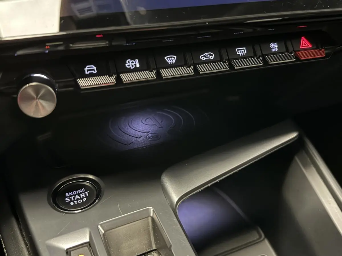 Gros plan sur la console centrale intérieure de la Peugeot 308 SW gris, avec bouton start/stop et commandes climatisation.