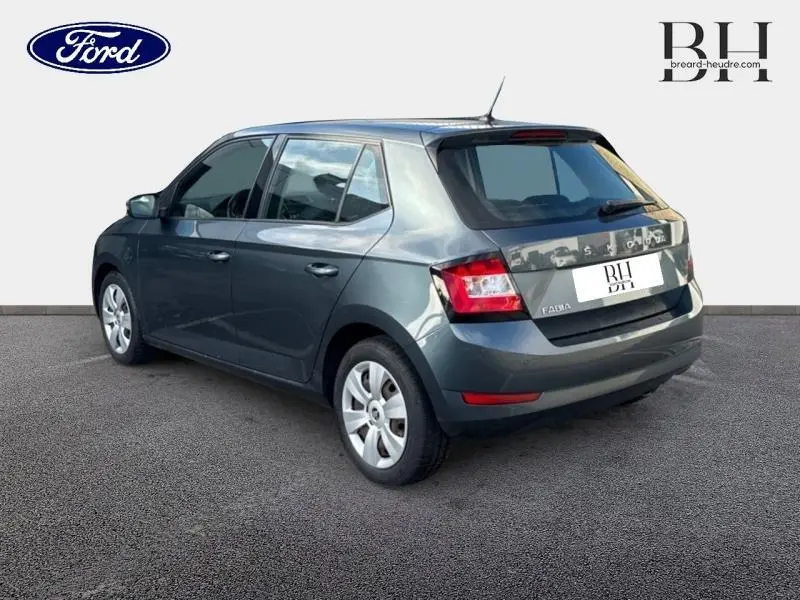 Vue 3/4 arrière droite d'une Skoda Fabia gris météore avec feux arrière nets et jantes argentées.