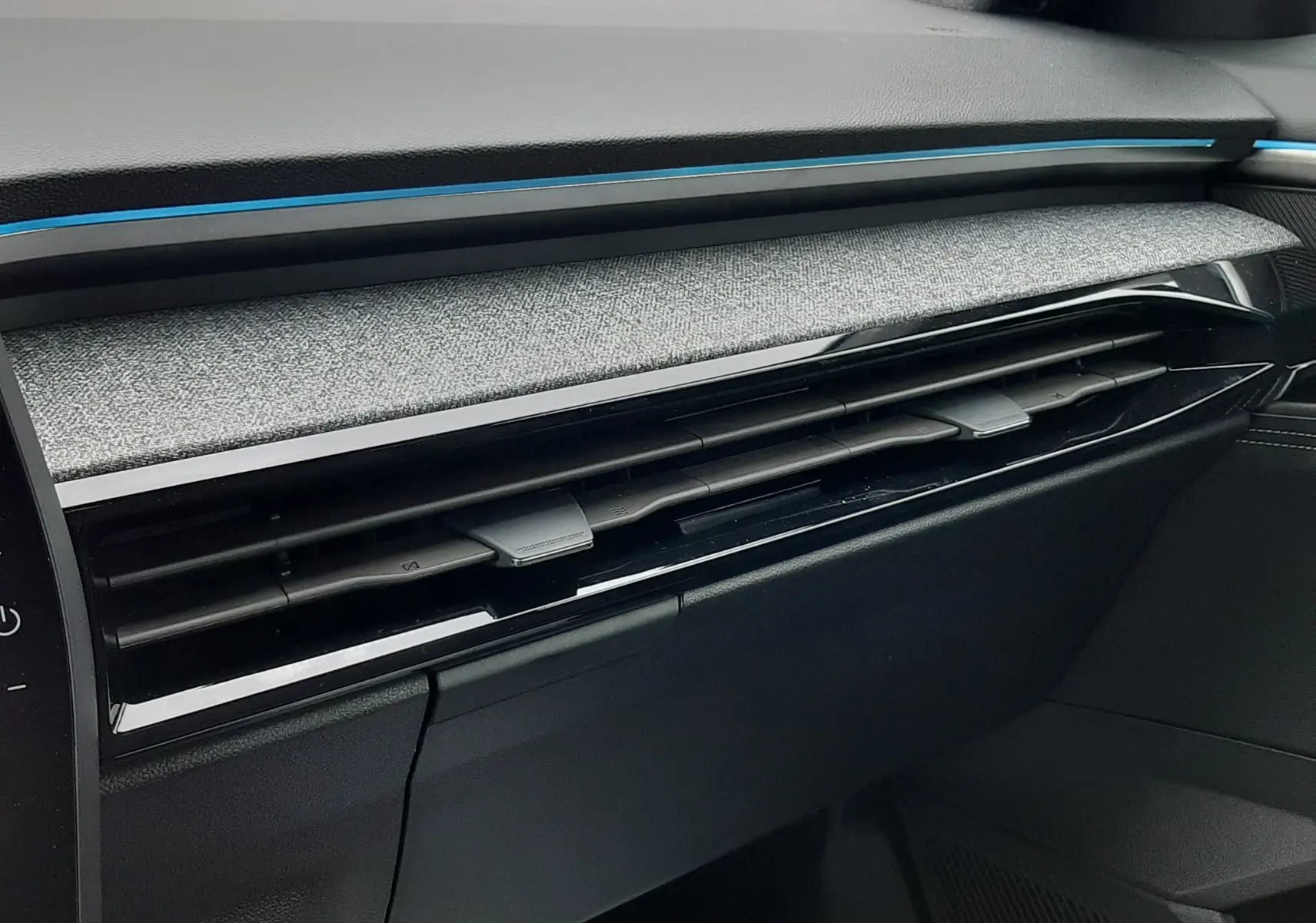 Détail de la planche de bord côté passager du Renault Austral Ph.2 gris schiste, avec bandeau décoratif bleu et aérateurs noirs.