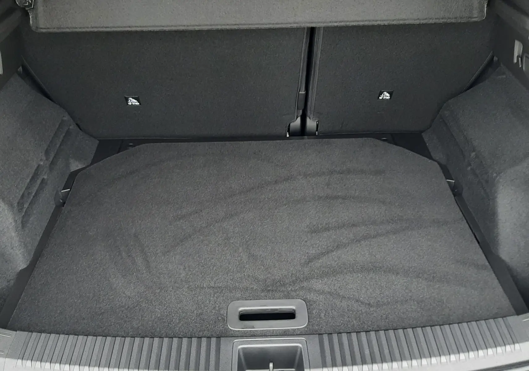 Vue intérieure du coffre spacieux et tapissé de tissu noir du Renault Austral Ph.2 gris schiste, version hybride 2025.