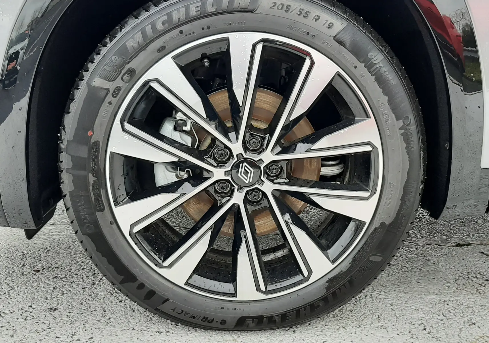 Gros plan sur la roue avant droite du Renault Austral Ph.2 gris schiste, avec jante alliage bicolore et pneu Michelin.