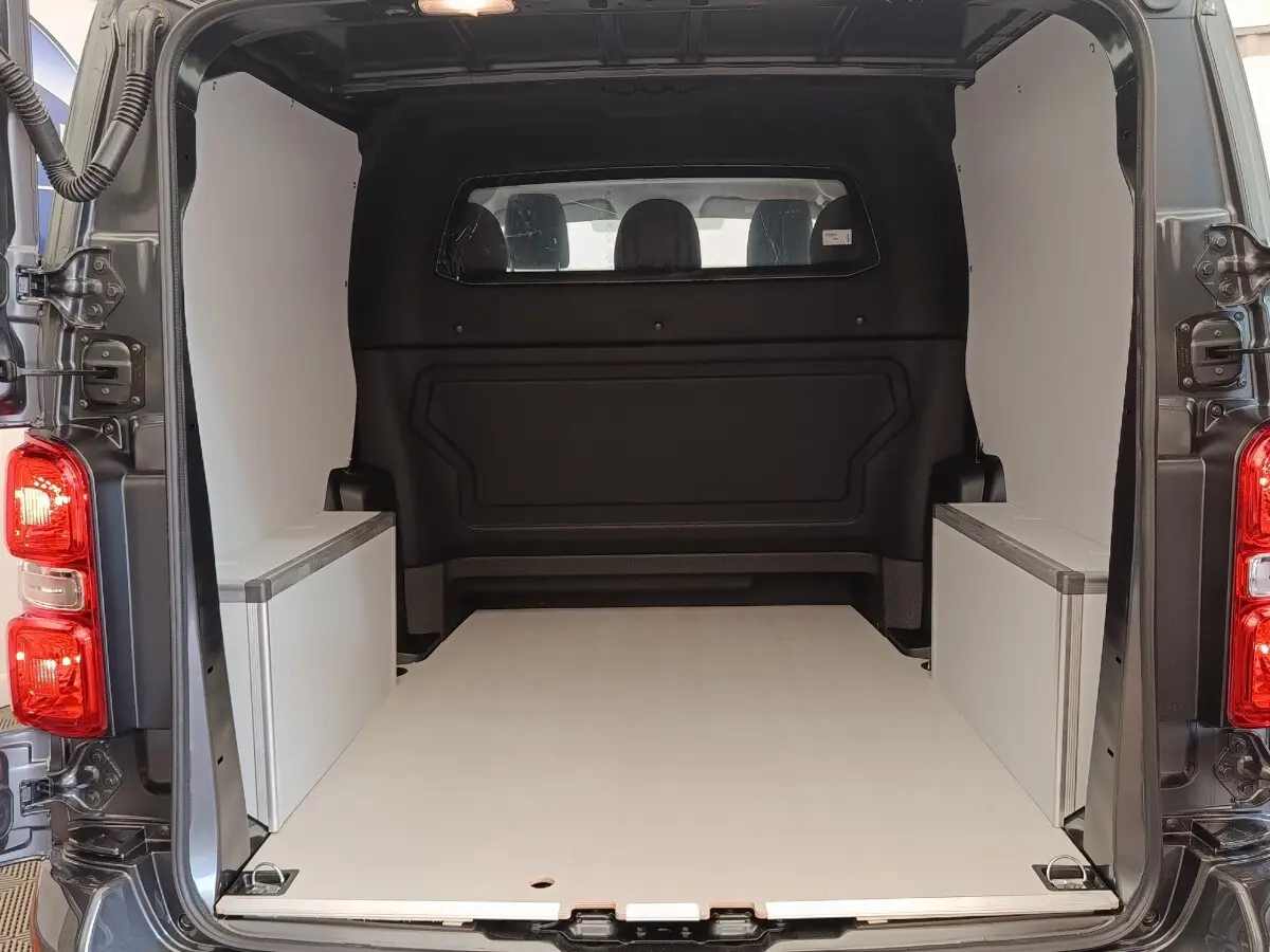 Vue arrière du Citroën Jumpy gris foncé 2025 montrant l’espace de chargement vide avec cloison vitrée pleine.