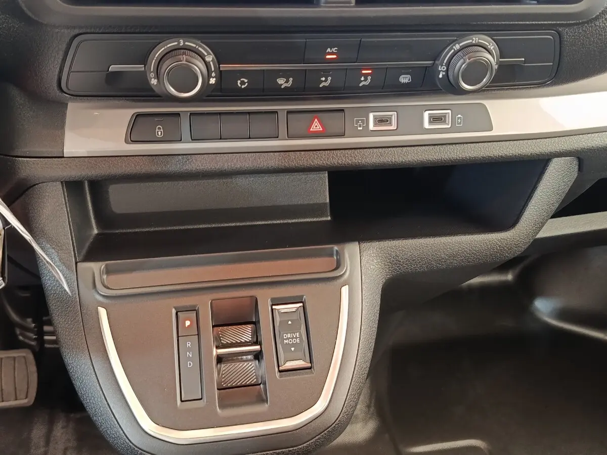 Gros plan sur la console centrale du Citroën Jumpy gris foncé, montrant commandes climatisation et boîte automatique.