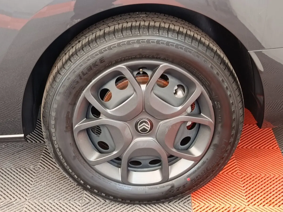 Gros plan sur la roue arrière droite d'un Citroën Jumpy gris foncé, avec partie de la carrosserie visible.