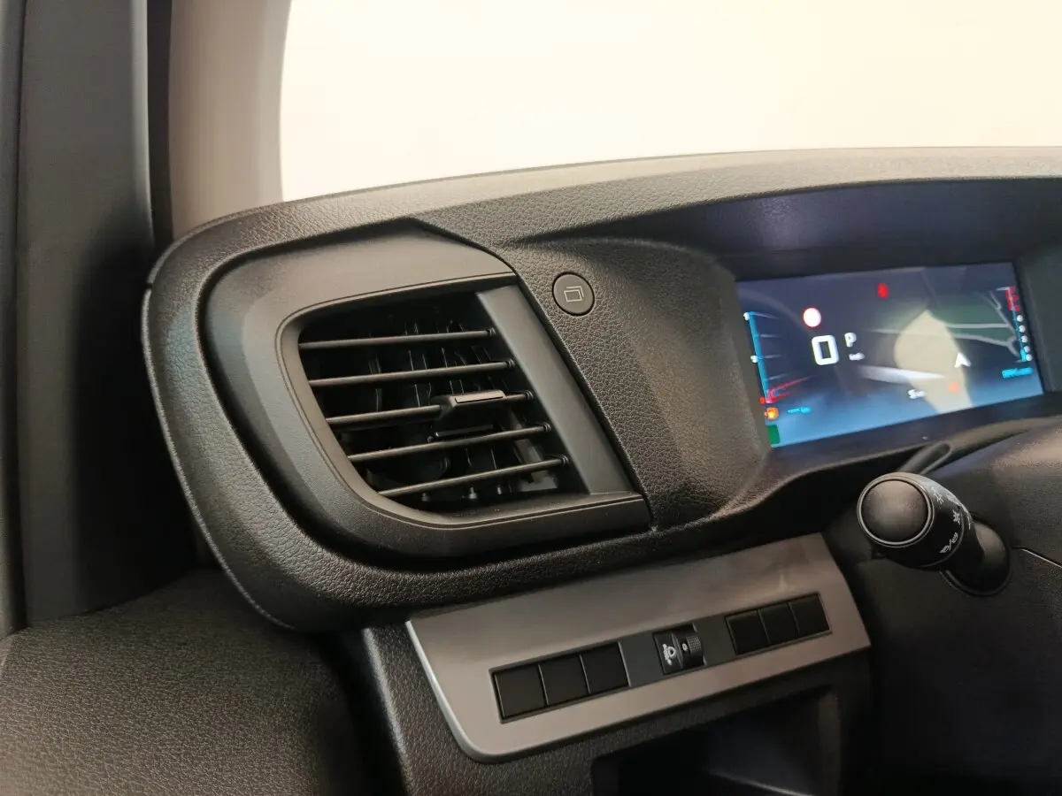 Détail intérieur côté gauche du tableau de bord gris foncé avec diffuseur d'air et écran numérique du Citroën Jumpy 2025.
