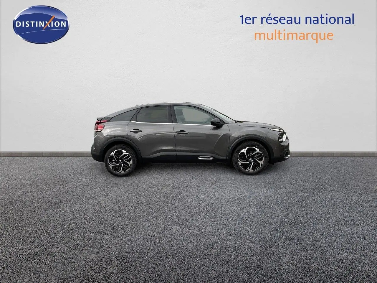 Profil côté gauche d'une Citroën C4 2024 gris platinium métal avec jantes noires et toit noir contrasté.