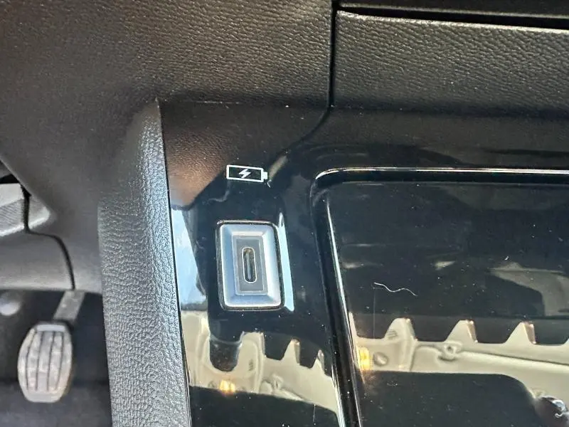 Prise USB-C de recharge visible sur la console centrale noire du Peugeot 208 1.2 100ch Allure essence 2024.