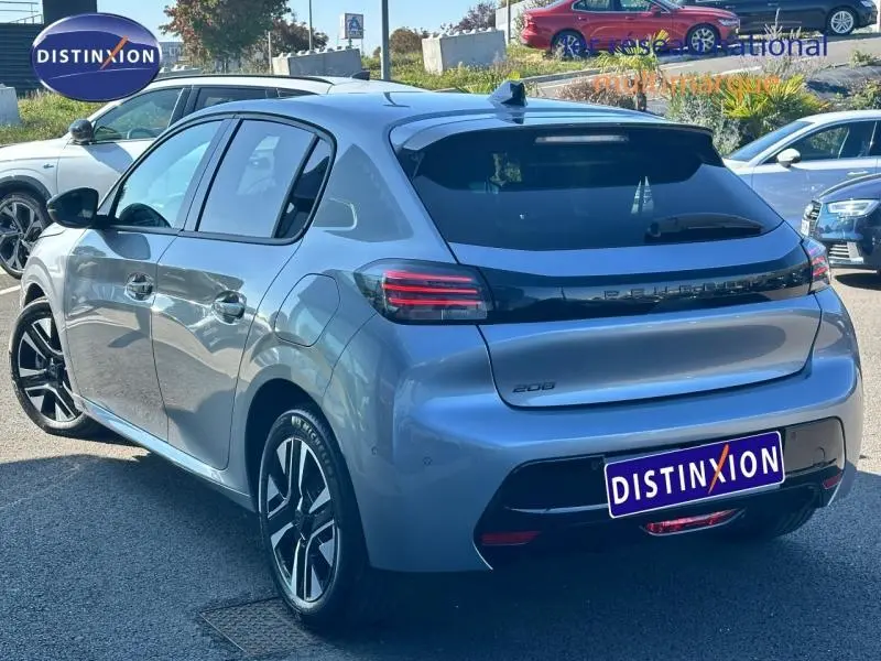 Vue 3/4 arrière droite d'une Peugeot 208 gris métallisé 2024 avec feux arrière LED et jantes alliage distinctives.