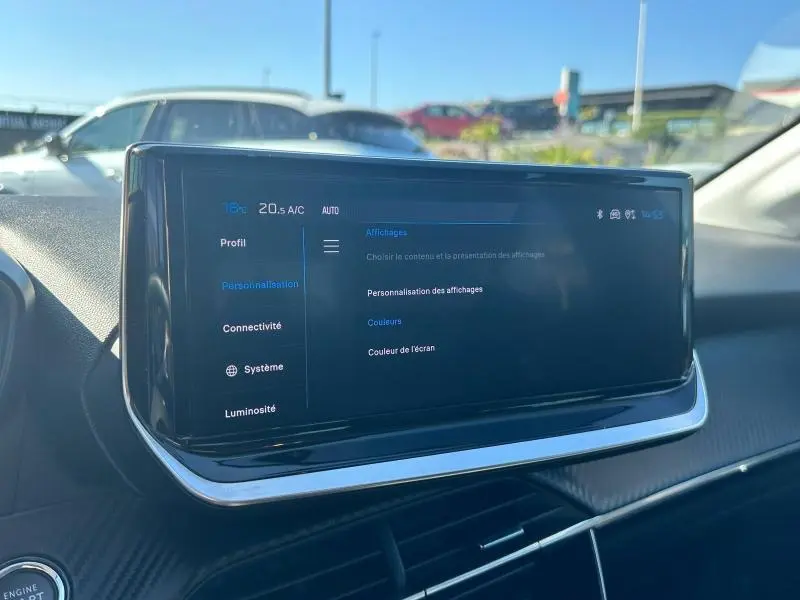 Écran tactile central du tableau de bord de la Peugeot 208 gris 2024, affichant les réglages de personnalisation.