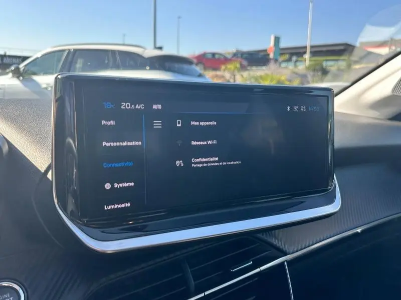 Écran tactile central du tableau de bord de la Peugeot 208 2024, affichant les réglages de connectivité et Wi-Fi.