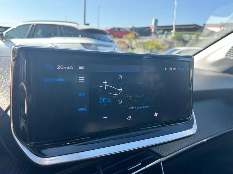 Écran tactile central du tableau de bord du Peugeot 208 gris 2024, affichant les réglages de climatisation.