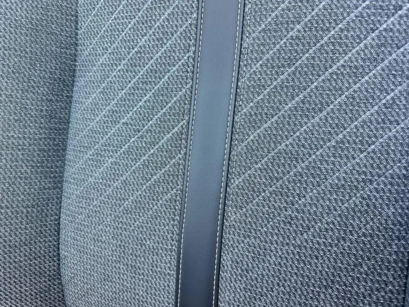 Détail du tissu gris à motifs et bande centrale en cuir sur le siège avant de la Peugeot 208 1.2 100ch Allure 2024